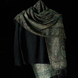 Dark teal Tibetan paisley wrap shawl with fringe worn over shoulder on dress form, three-quarter view