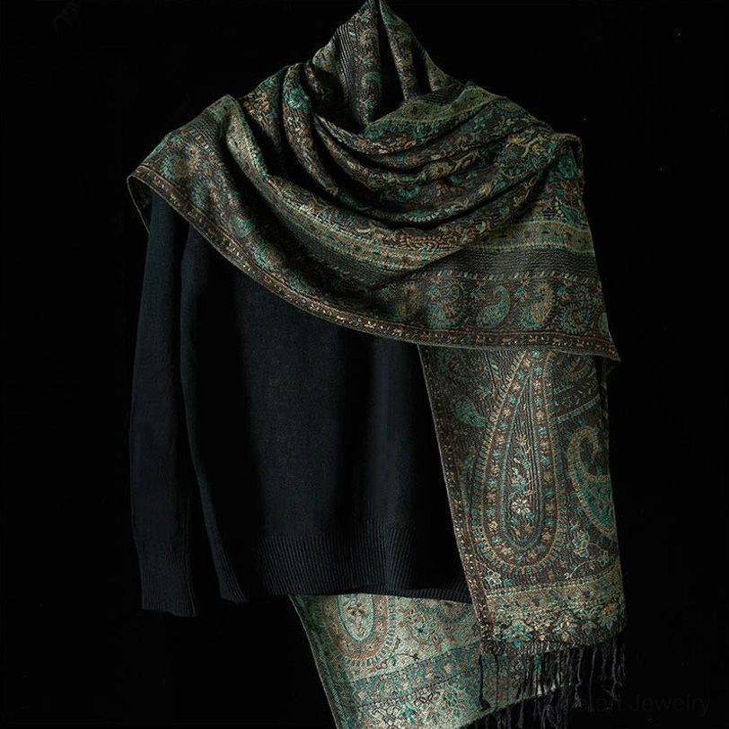 Dark teal Tibetan paisley wrap shawl with fringe worn over shoulder on dress form, three-quarter view