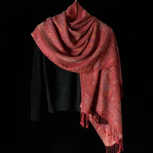 Three-quarter view of Tibetan paisley shawl with visible dual-side tassels, worn with black sweater