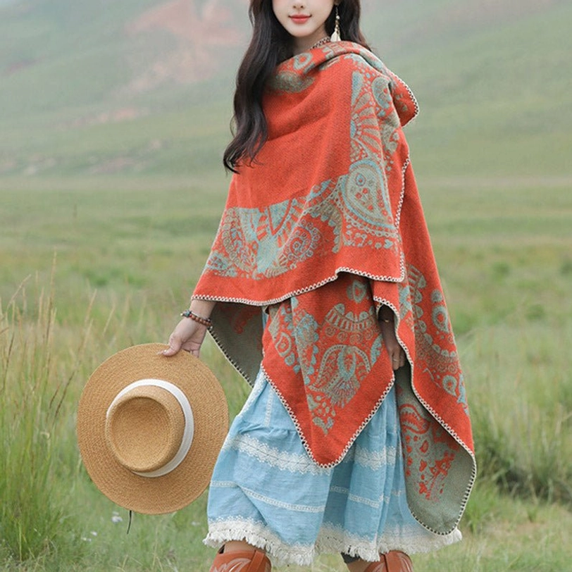 Dual-tone paisley print Tibetan wrap draped open-front style, right three-quarter view with alpine grassland backdrop