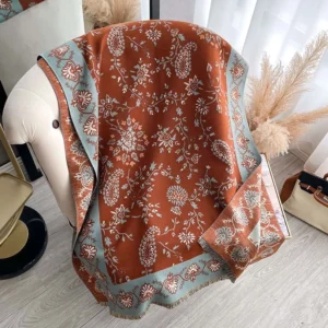Tibetan handwoven paisley shawl flat lay view with rust brown woven fabric and blue paisley border