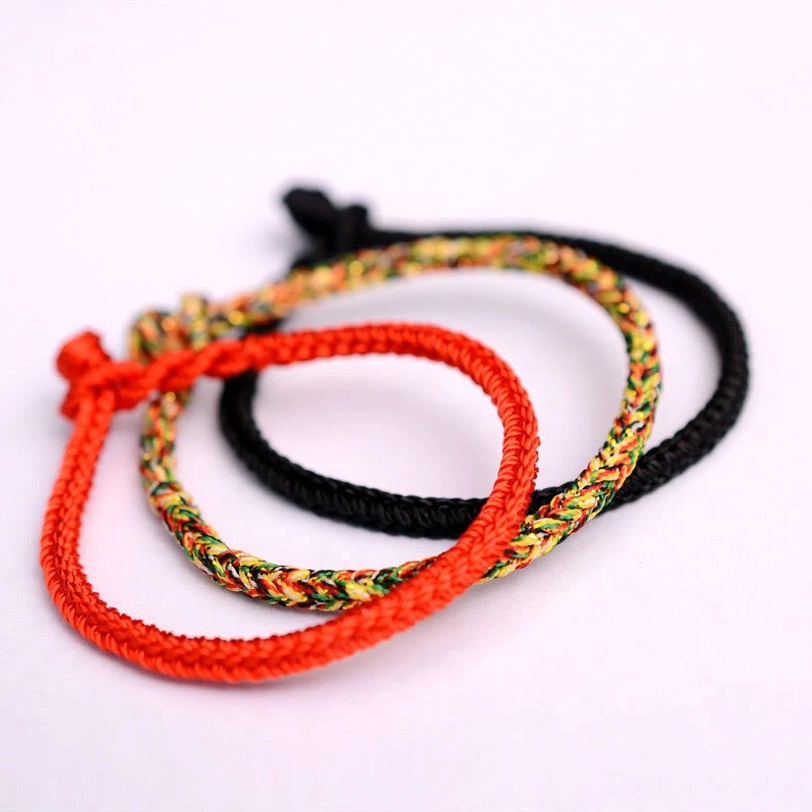 Set of multiple tibetan eight-thread peace knot bracelets in red black and multicolor styles flat lay collection