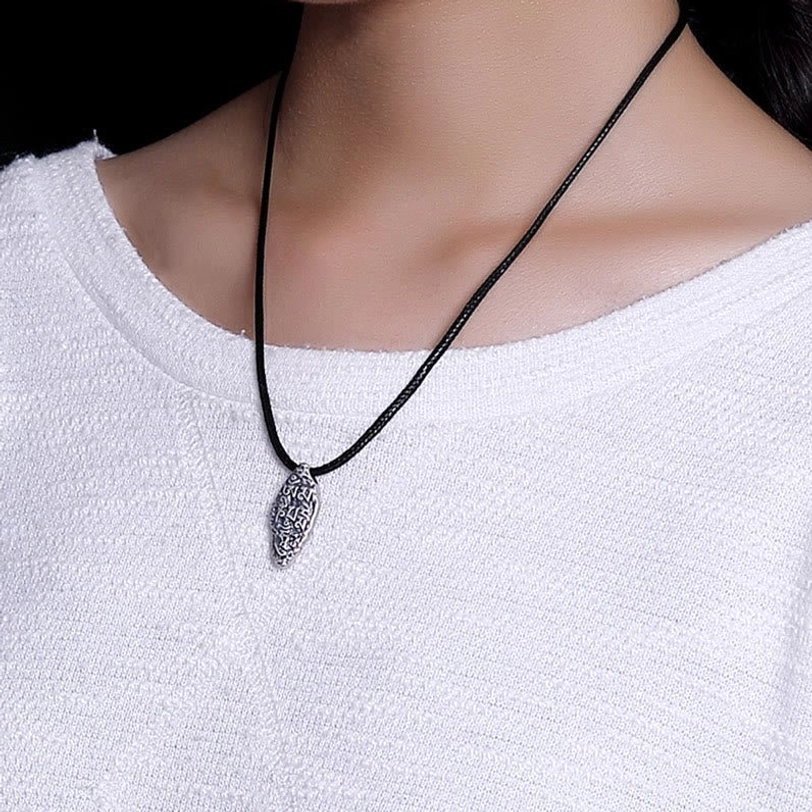 Woman wearing Tibetan Om Mani Padme Hum sterling silver necklace pendant on thin black wax cord, close-up neck view