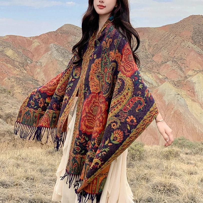 Tibetan peony tassel shawl worn over white dress in outdoor mountain landscape, full body view showcasing ethnic floral print and fringe detail
