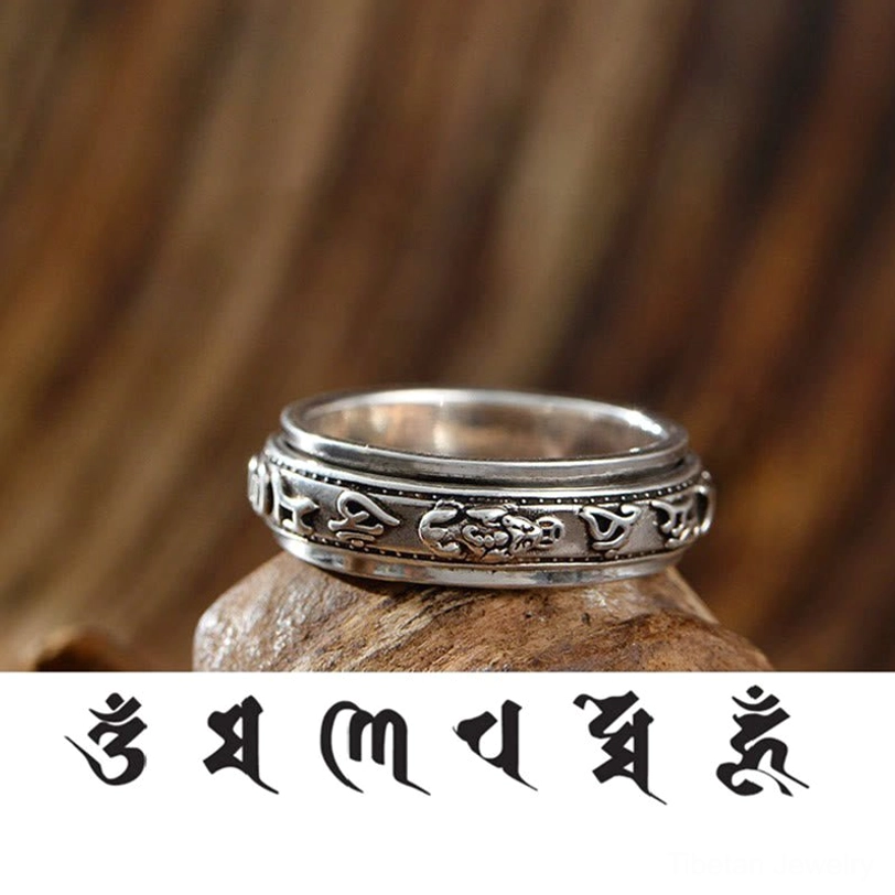 Vintage silver Tibetan Om Mani Padme Hum Pixiu ring displayed on wooden surface with engraved details