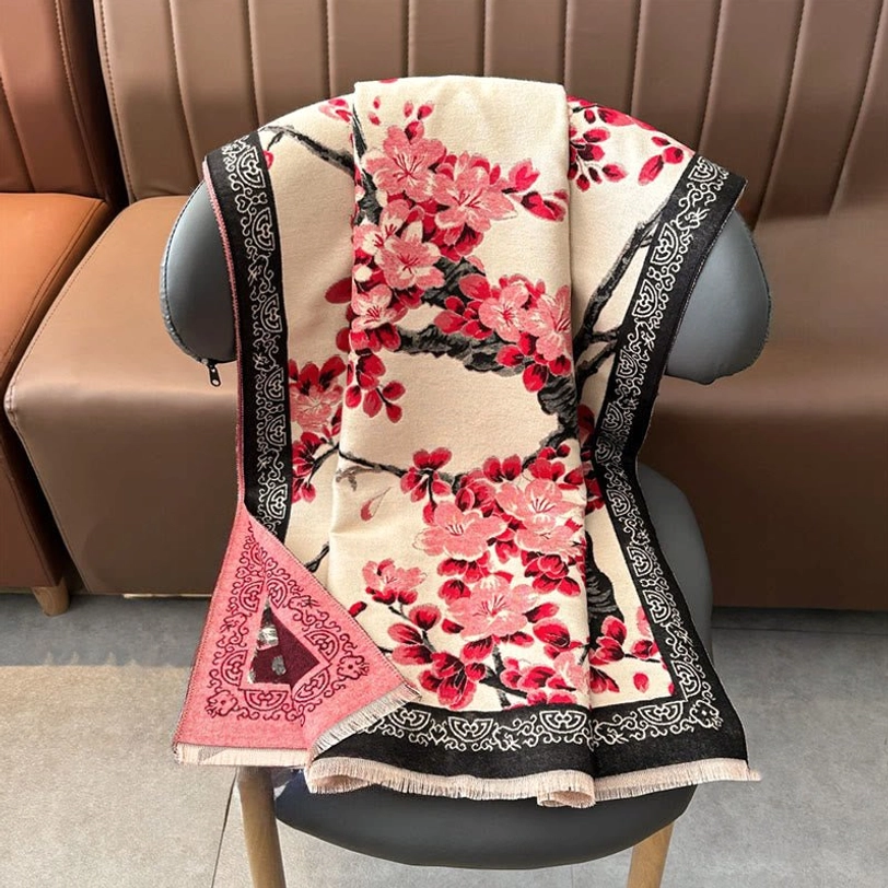 Back view of beige Tibetan scarf on sofa showing black embroidered border, tassel hem, and decorative pocket detail