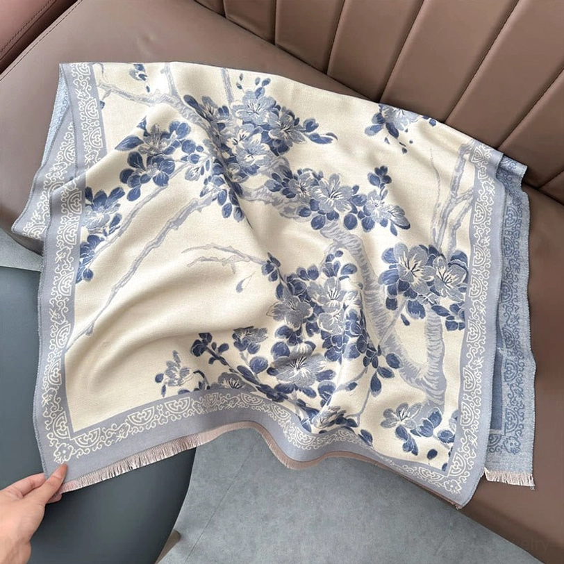 Light steel blue Tibetan plum blossom scarf flat lay on sofa showing complete plum blossom floral pattern and borders