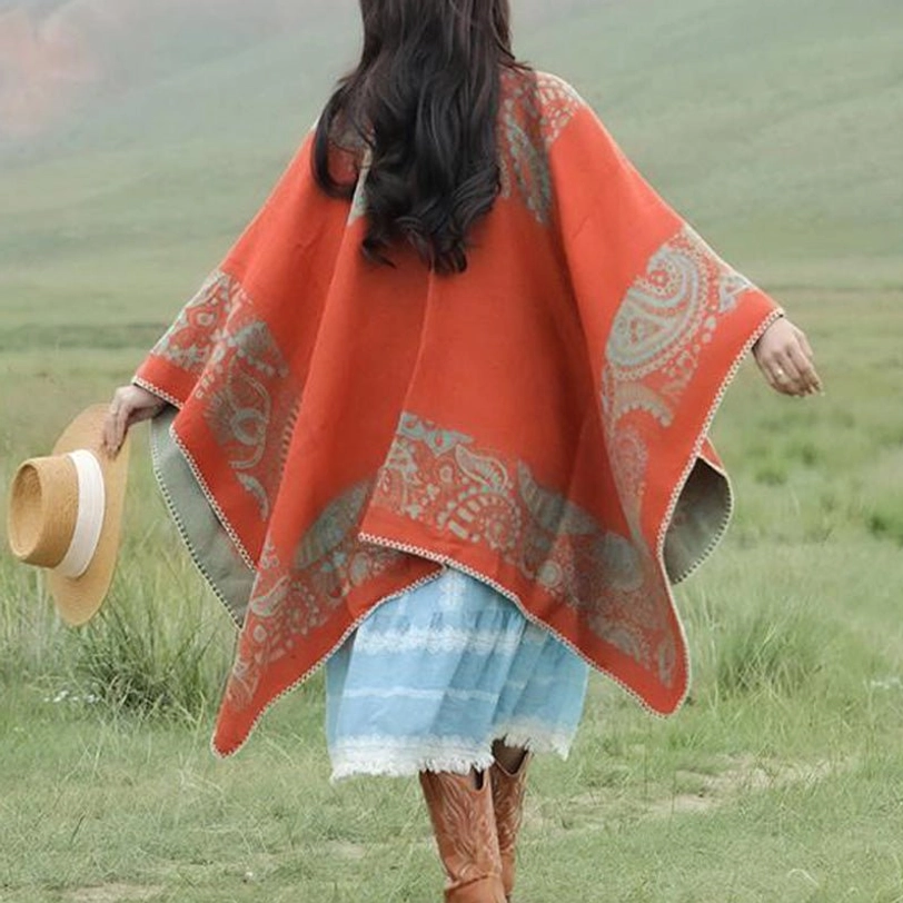 Full back view of Tibetan open-back poncho with complete paisley jacquard design on Alpine grassland