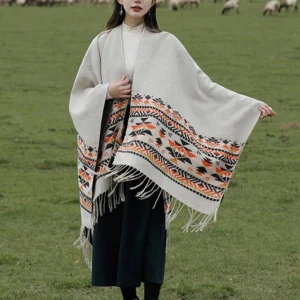 Tibetan geometric poncho shawl beige aztec pattern outdoor three-quarter view