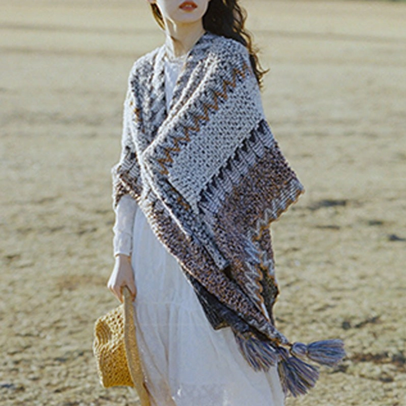 Tibetan knit poncho shawl with tassels worn casually over sweater in everyday style