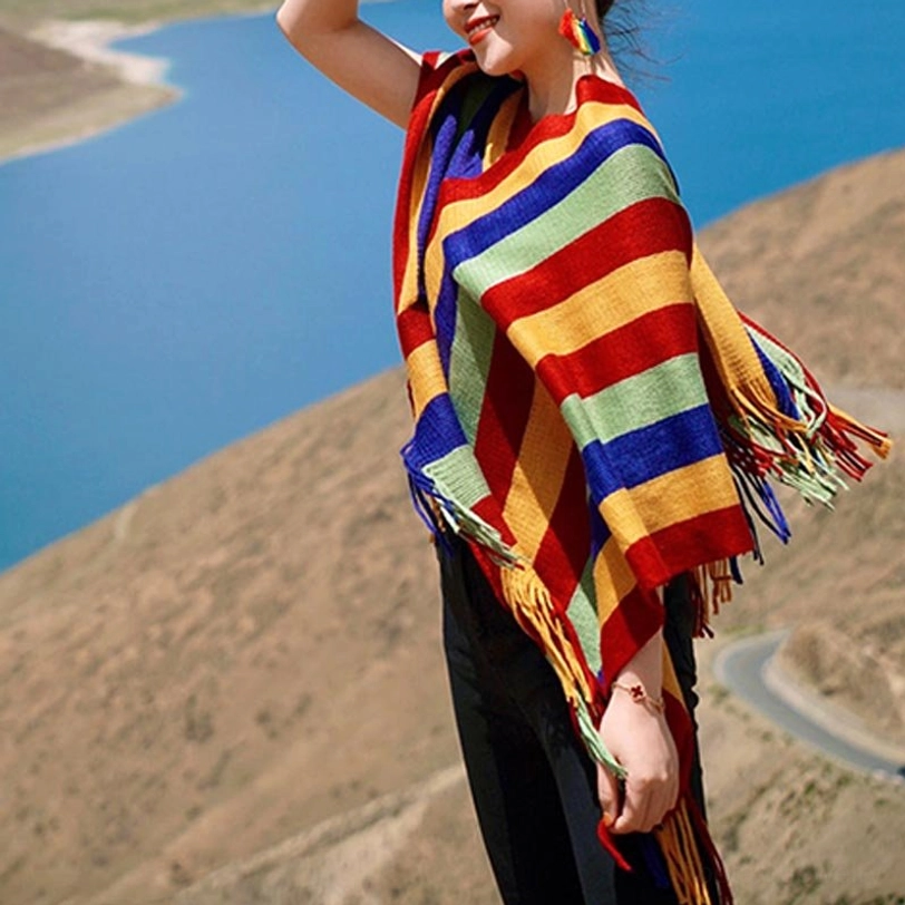 Tibetan striped poncho shawl side full-body view with natural hanging tassels worn lakeside mountain area