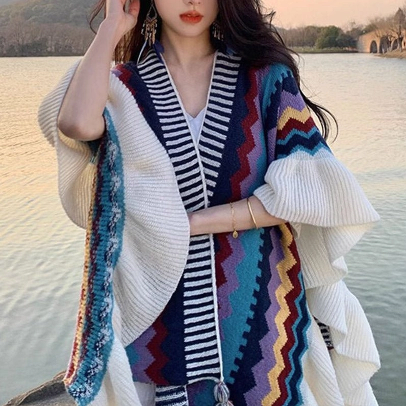 Model wearing Tibetan striped poncho shawl at lakeside sunset featuring V-neck ruffled flounce and ethnic color design