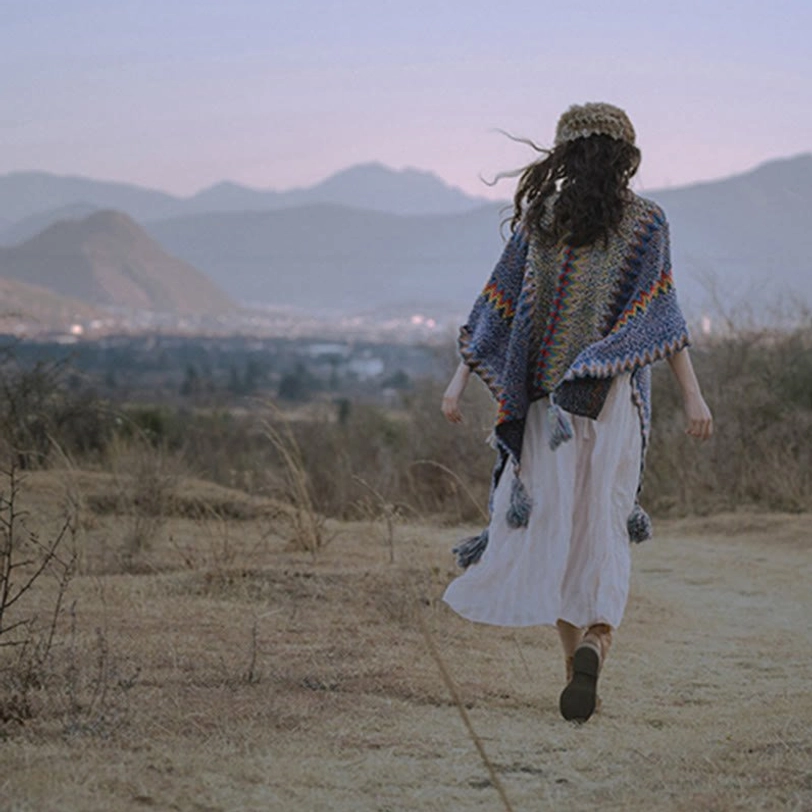 Tibetan poncho cape displayed as cozy throw blanket over furniture showing versatility and warmth