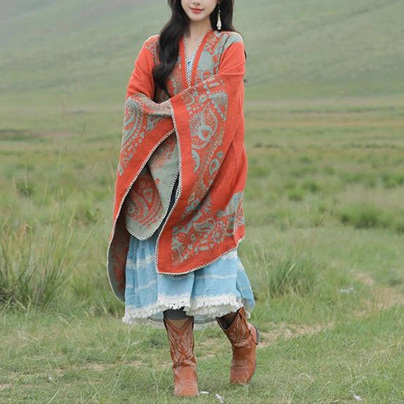 Full front view of open-front Tibetan poncho with V-neck reversible dual-color design on grassland background