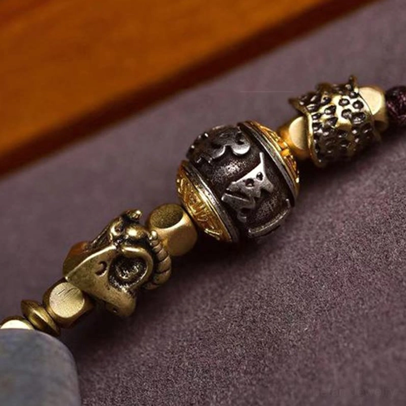 Traditional Tibetan mantra carved prayer beads with brass skull charms and gold-toned metal accents