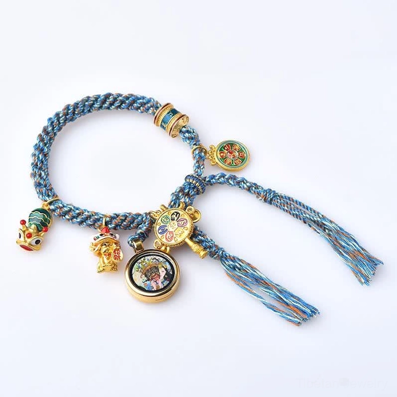 Tibetan thangka prayer bracelet with blue woven rope and thangka pendant on white background
