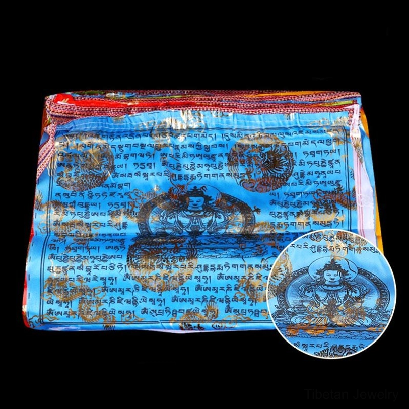 Close-up of red tibetan prayer flag with black sutras and red buddha image highlighted with gold foil accents on vibrant red base