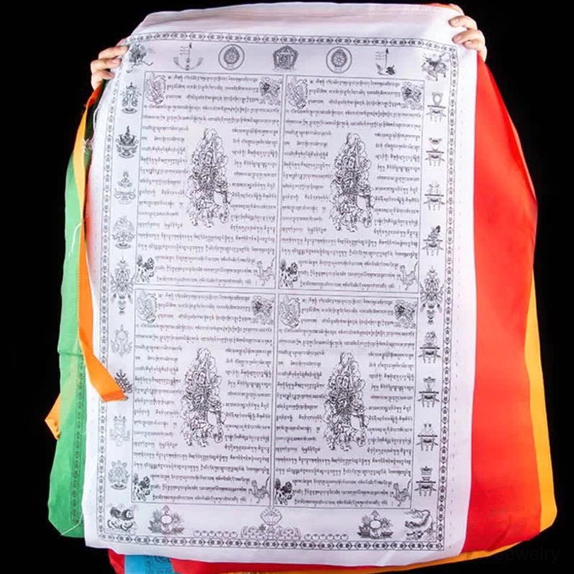 White-based Tibetan prayer flag held in hands displaying black printed religious symbols paired with red, green and blue sacred color borders