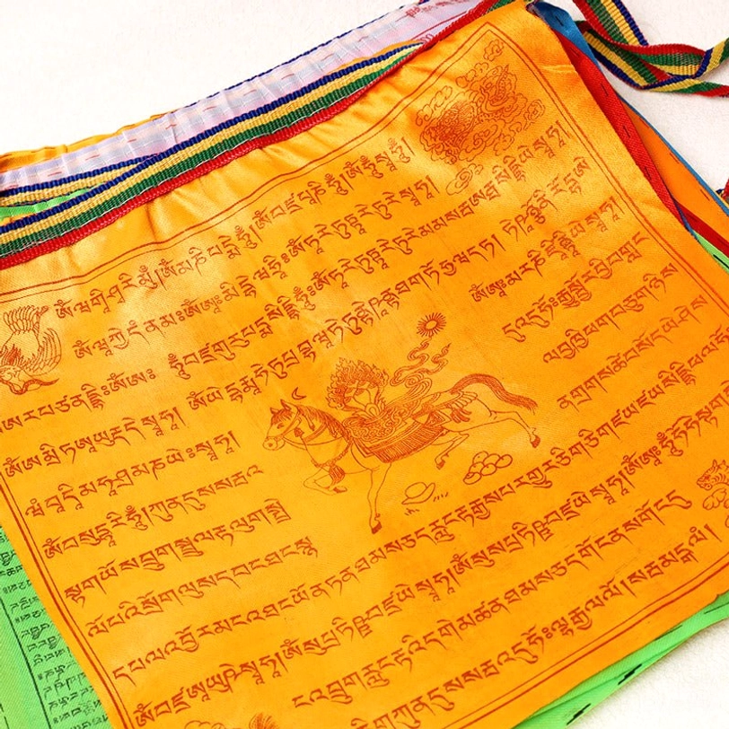 Single orange Tibetan prayer flag close-up with windhorse deity and Tibetan script