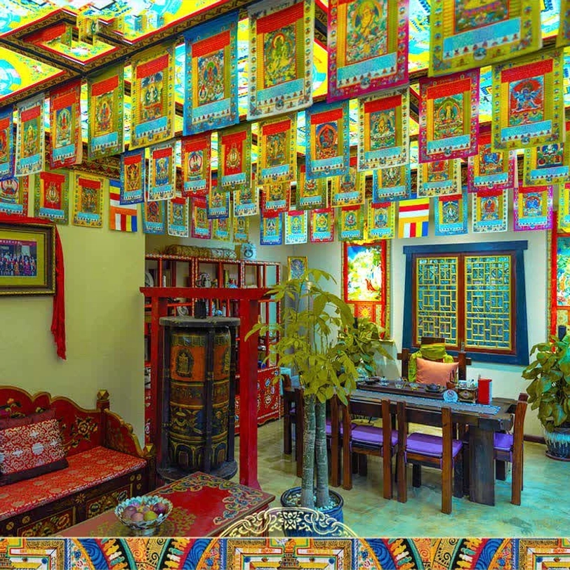 Multiple Tibetan prayer flag strings densely arranged in traditional dining room, creating full spiritual atmosphere with vibrant colorful array