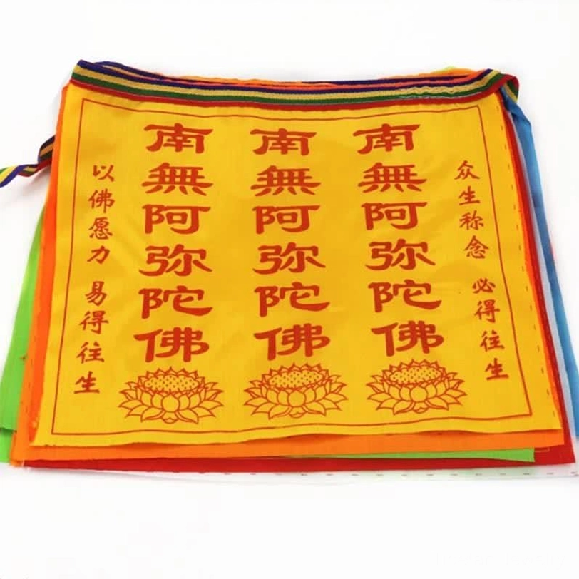 Yellow Tibetan prayer flag with red lotus print and Buddhist verses visible