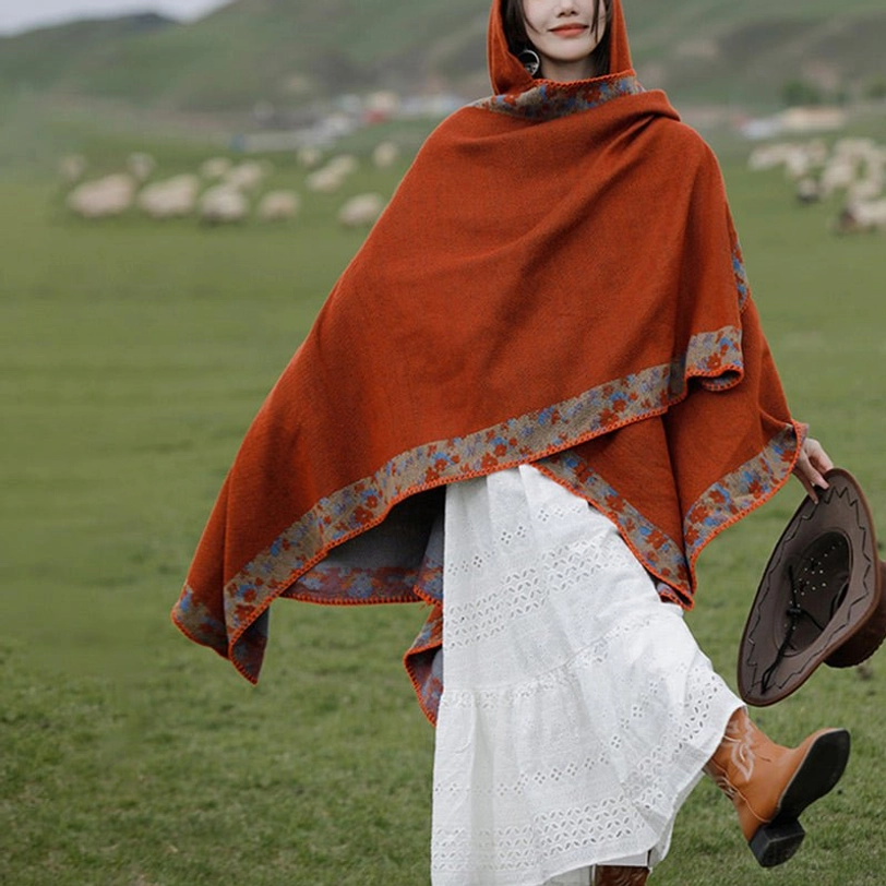 Tibetan prayer shawl worn open without hood, right front view with cowboy hat styling and sheep background