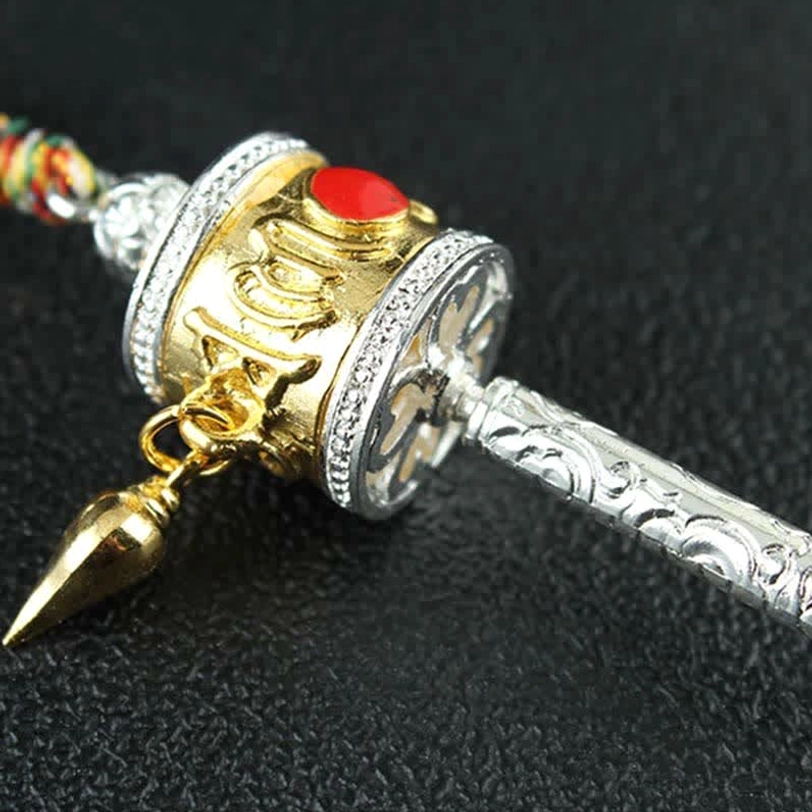Tibetan prayer wheel hanging ornament with traditional braided cord and metal charm attachments for car or home spiritual decor