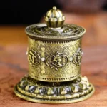 Tibetan prayer wheel car decoration bronze finish overhead view with lotus engraving and Om Mani Padme Hum mantra