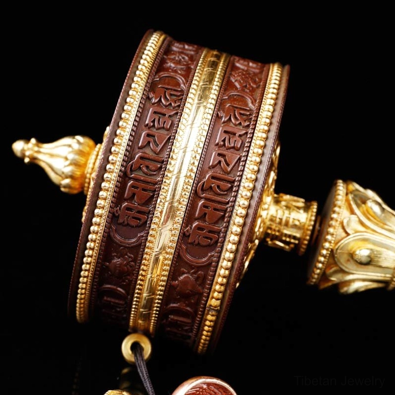 Prayer wheel cylinder side view showing metal spindle and ornamental bands