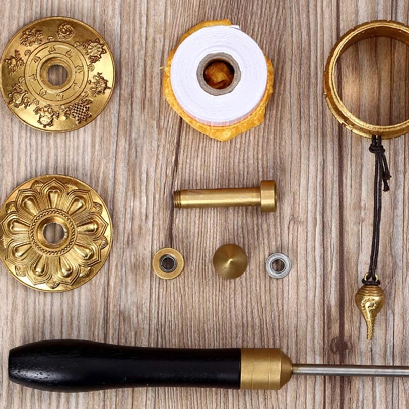 DIY tibetan prayer wheel assembly kit showing metal fittings mantra roll wooden handle and decorative components