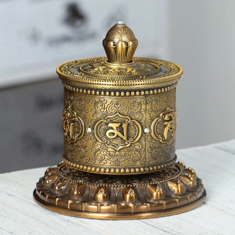 Gold Tibetan prayer wheel front full view with lotus-shaped base and smooth bronze tone classic design