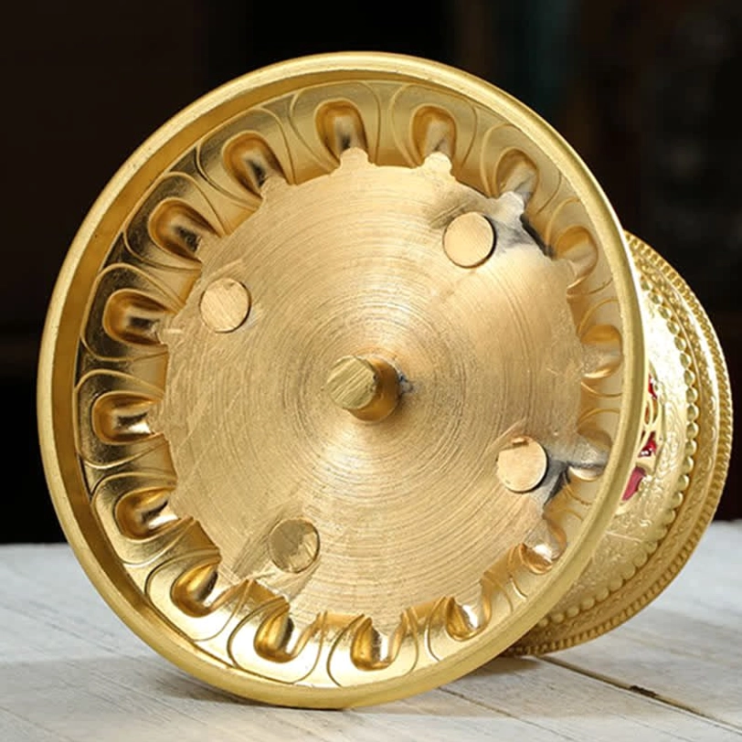 Tibetan prayer wheel blessing charm close-up showing intricate mantra engraving and spiritual symbolism