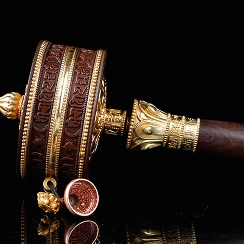 Tibetan prayer wheel oblique view with engraved sutra and bell decoration