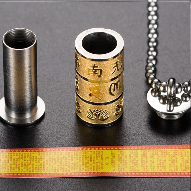 Disassembled Tibetan prayer wheel pendant showing rotatable mechanism, base, and necklace chain components