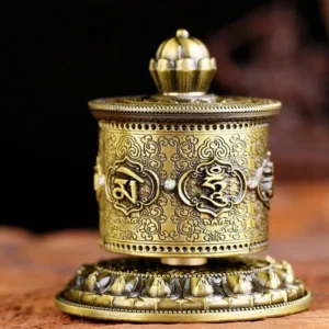 Red Tibetan prayer wheel decoration front view showing embossed mantra and decorative studs on dark background
