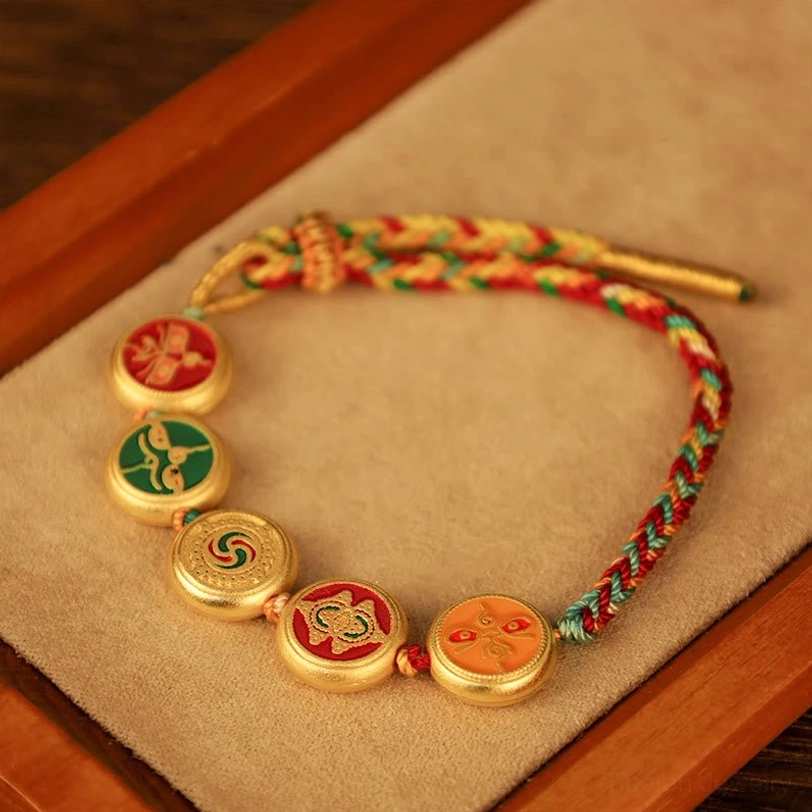 Tibetan spiritual prosperity bracelet close-up detail of five colored enamel charms representing wealth deities and gold-plated accents