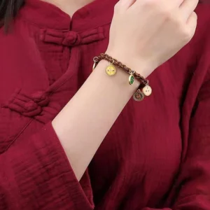 Woman wearing Tibetan Five God of Wealth bracelet on wrist with red traditional clothing