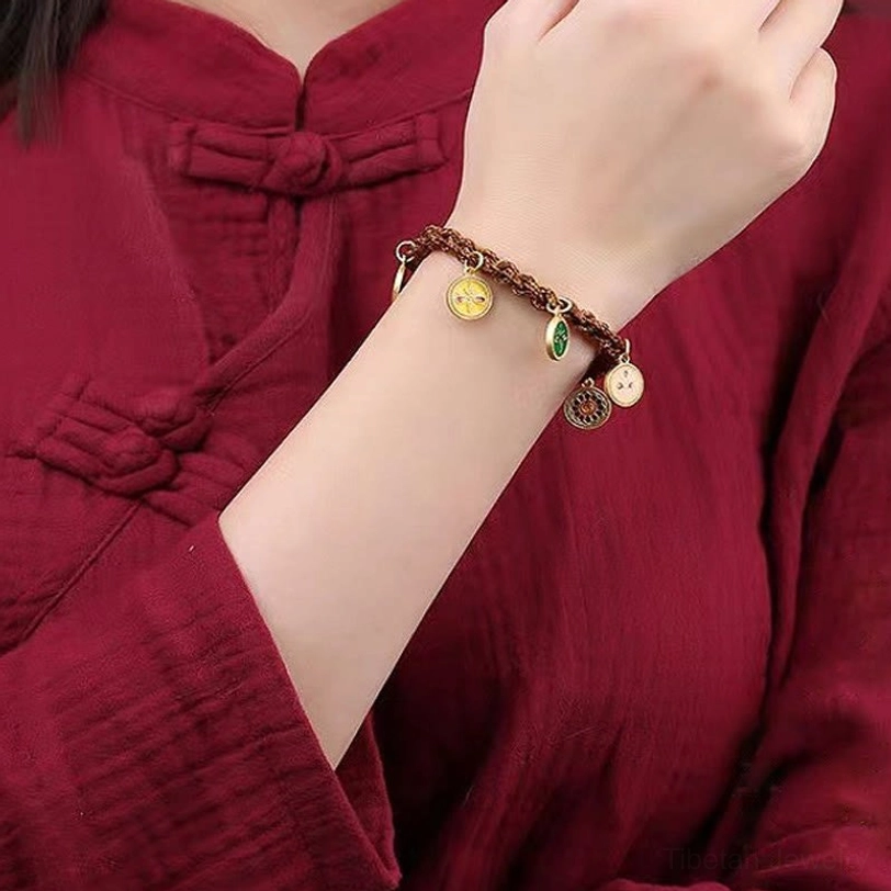Woman wearing Tibetan Five God of Wealth bracelet on wrist with red traditional clothing
