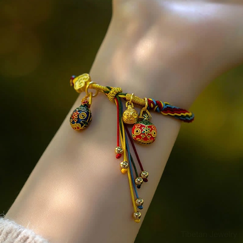 Wearable Tibetan prosperity bracelet on mannequin wrist showing multicolor cord, gold hardware, and protection tassel