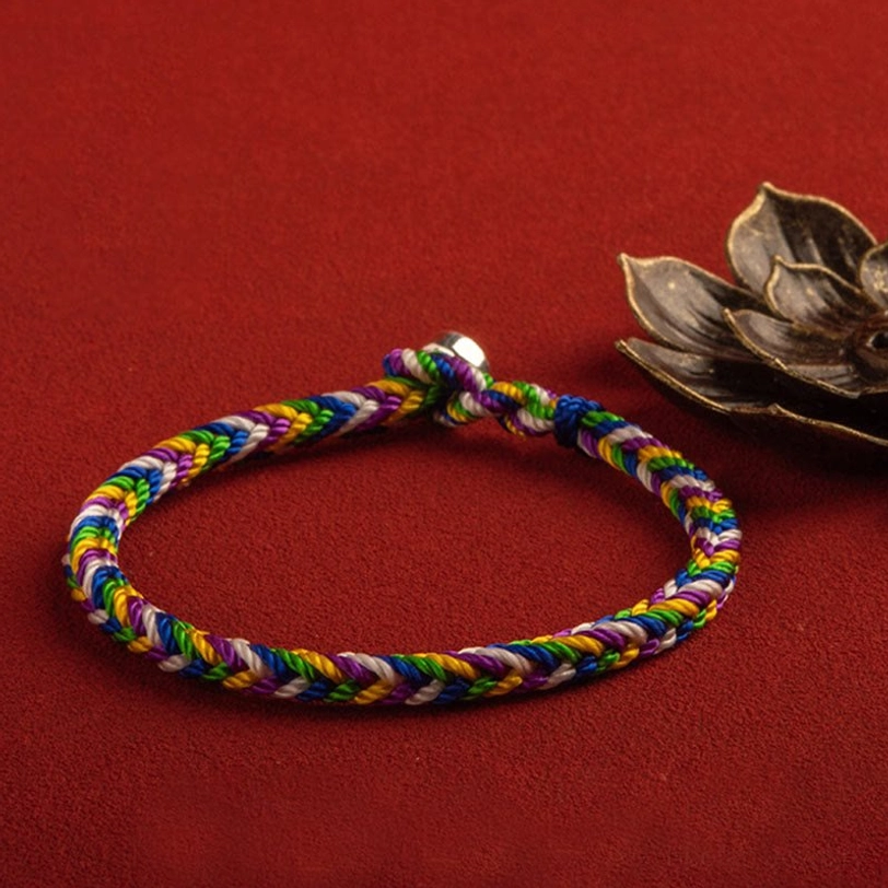 Multicolored braided Tibetan protection bracelet with 925 sterling silver clasp on red background