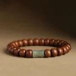 Tibetan Abelia Biflora wood and Hetian jade bracelet with bamboo spacer beads, front close-up view on warm brown background