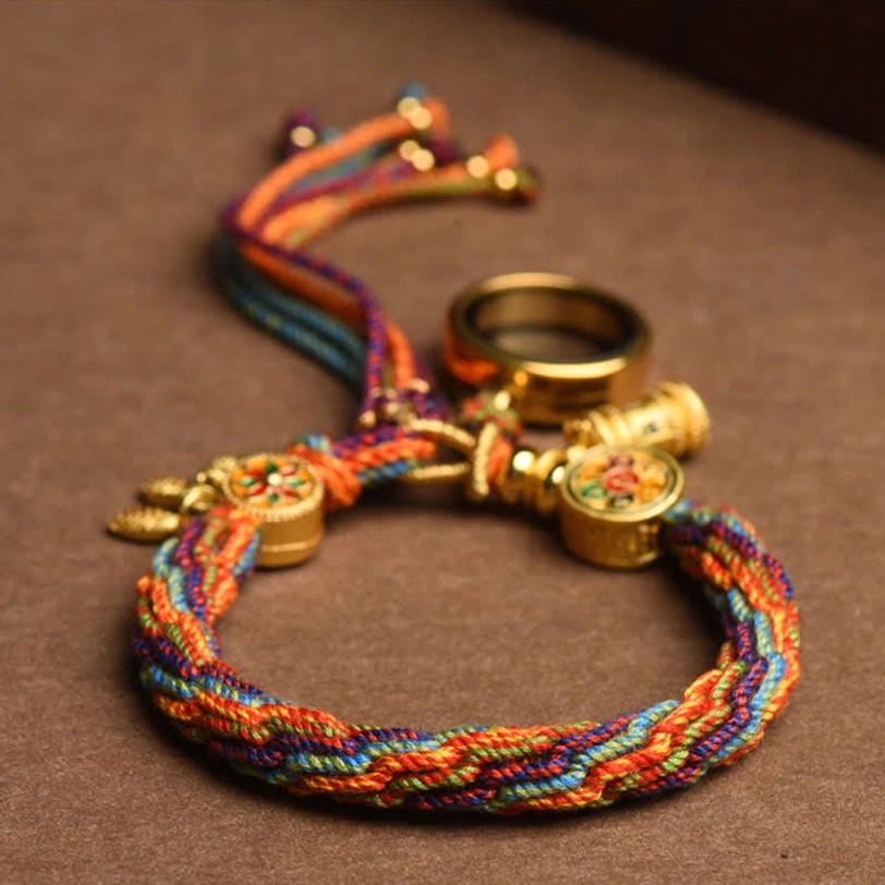 Adjustable Tibetan lucky bracelet with multicolor rope and tassel closure on dark wooden background