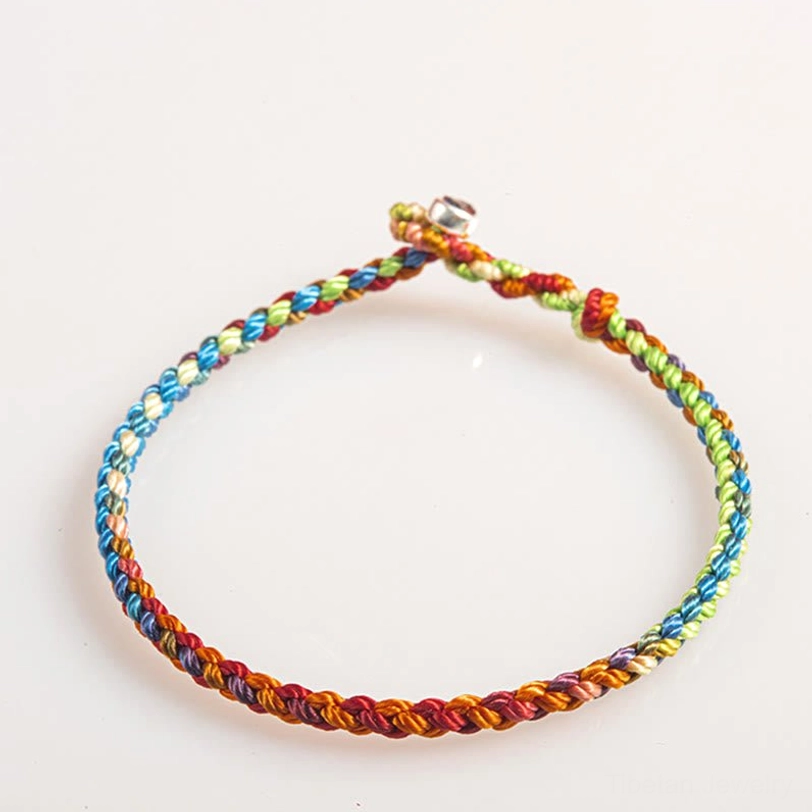 Tibetan handwoven bracelet with bell charm detail showcasing twisted rope weave pattern