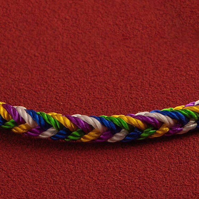 Close-up detail of braided five-color rope bracelet showing twisted thread texture and central knot