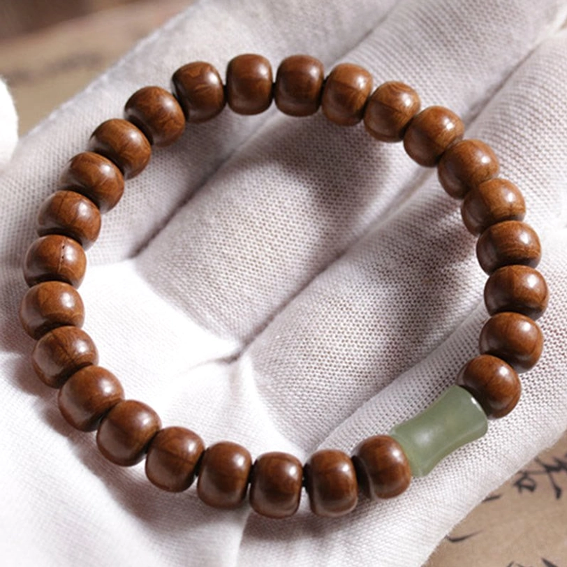 Abelia Biflora wood and Hetian jade Tibetan bracelet close-up worn on white fabric glove showing texture detail