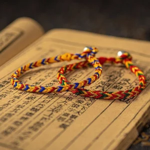 Two handmade Tibetan blessing cord bracelets flat lay showing different color combinations