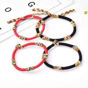 Set of Tibetan lucky protection bracelets in red and black with colorful knots flat lay display