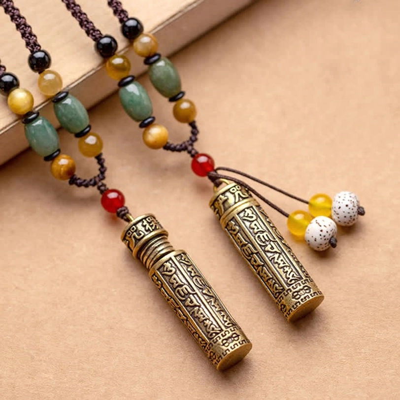 Two handmade Tibetan protection necklaces with bodhi seed tassels and stone beaded chains laying flat