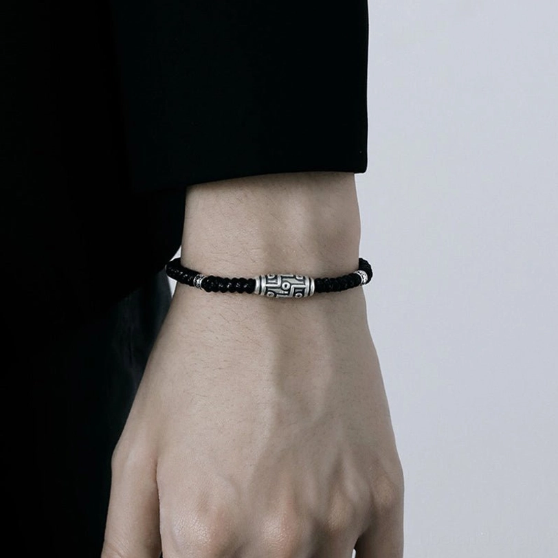Tibetan protection bracelet featuring nine-eye dzi bead in sterling silver, artistic styled photography with spiritual elements