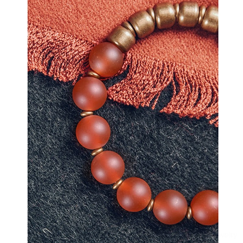 Mixed red agate and copper beaded bracelet flatlay showing round matte beads and vintage hardware